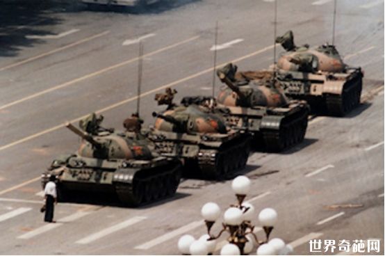 一个人站在一排移动的坦克前，拒绝移动